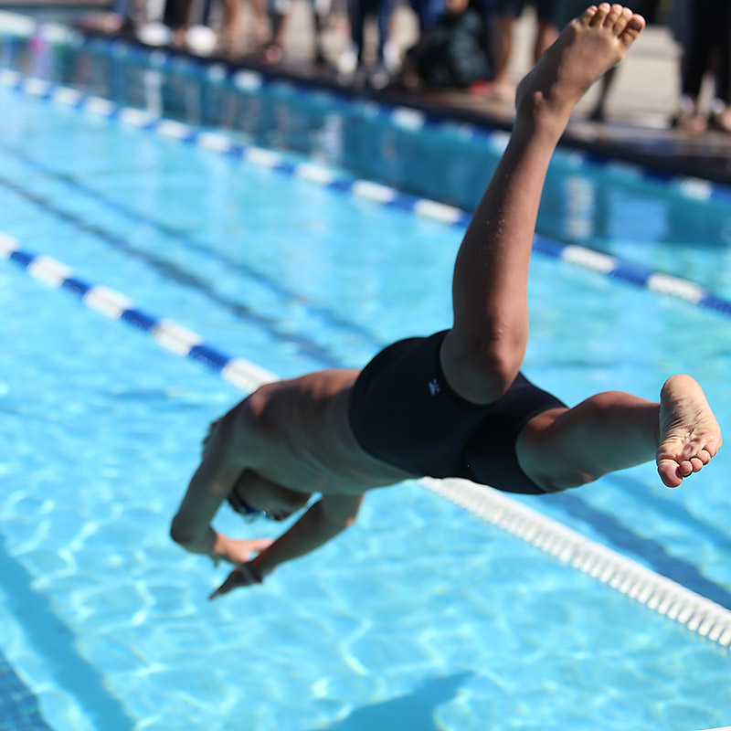 Young swimmer diving headfirst into a pool